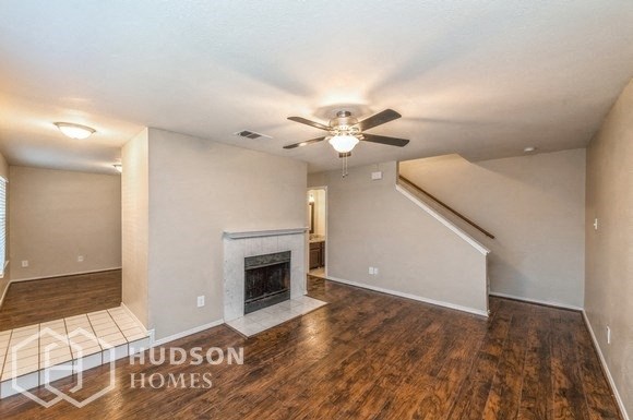 a living room with a fireplace and a ceiling fan