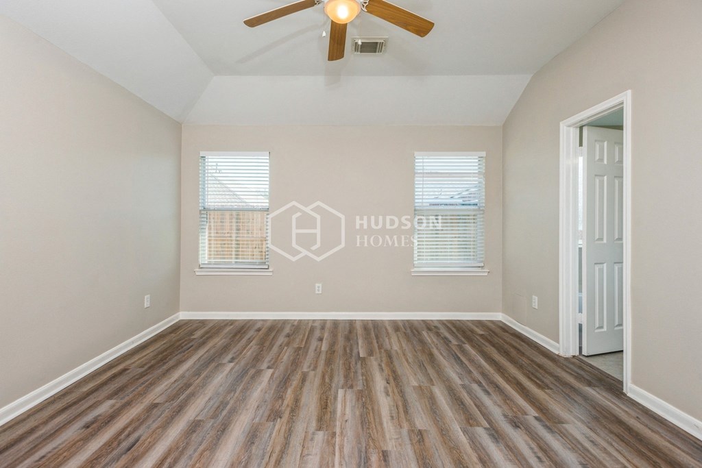 a living room with wood floors and a ceiling fan