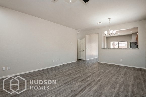 an empty living room and kitchen with wood flooring