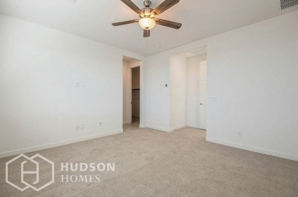 an empty living room with white walls and a ceiling fan