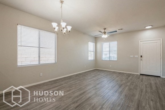an empty living room with wood floors and a ceiling fan