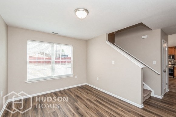 a living room with a staircase and a window