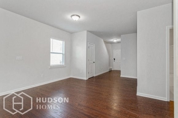 an empty living room with white walls and wood floors