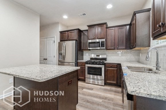 a kitchen with marble counter tops and wooden cabinets
