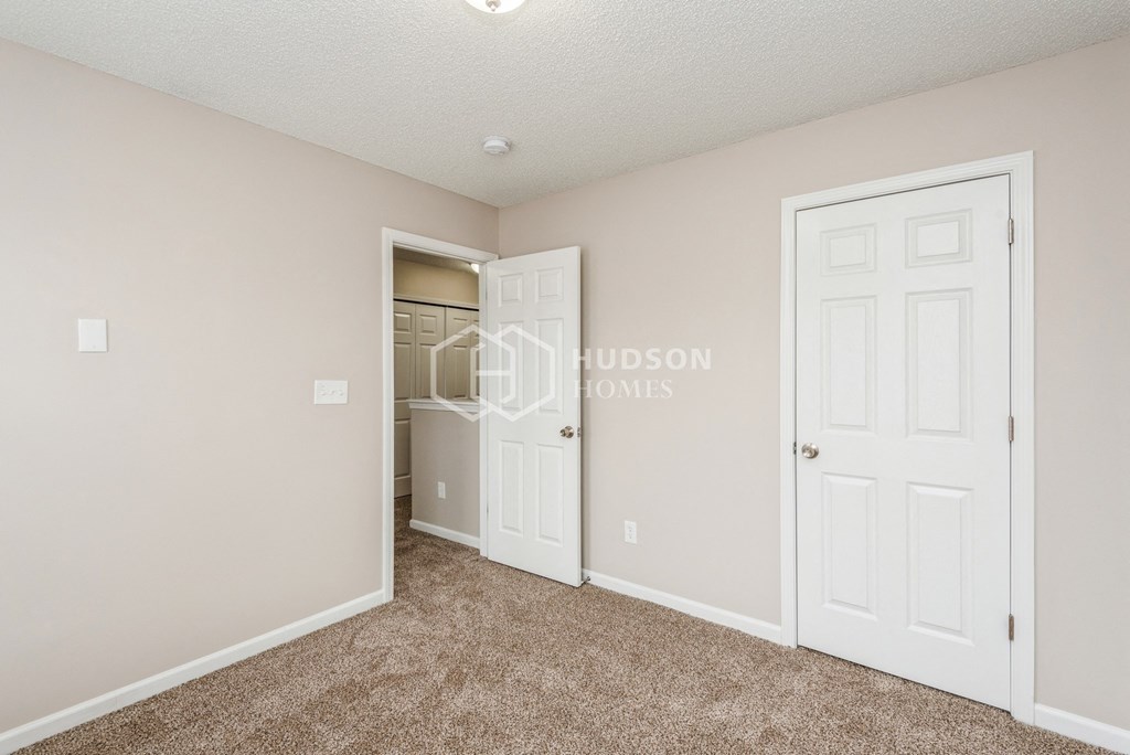 a bedroom with a closet and a white door