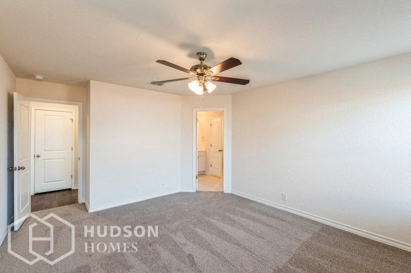 a living room with white walls and a ceiling fan