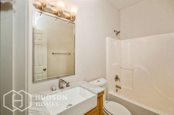 a white bathroom with a sink toilet and a mirror