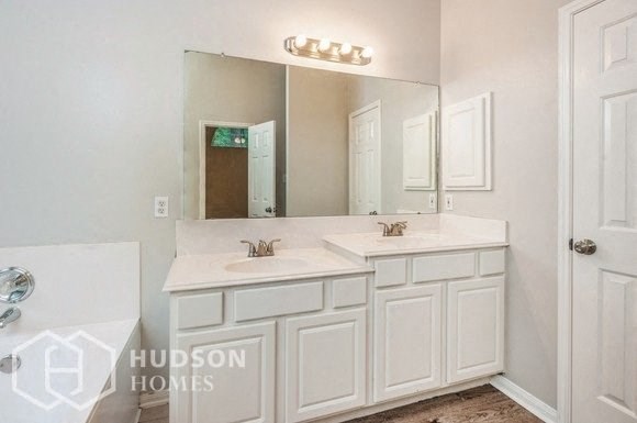 a white bathroom with two sinks and a mirror