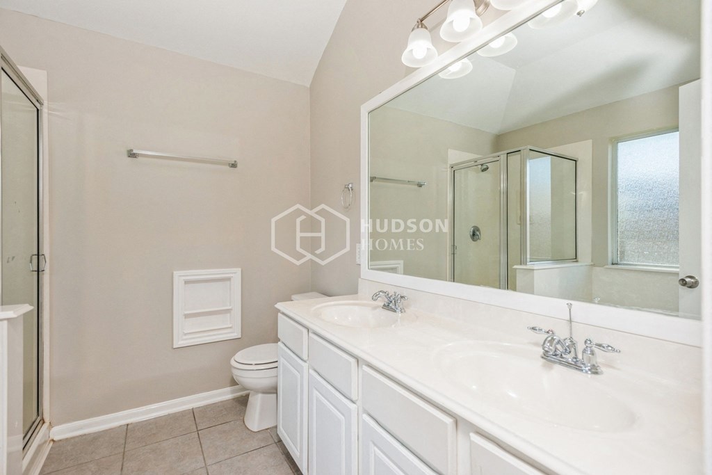 a white bathroom with a large mirror and a toilet and a sink