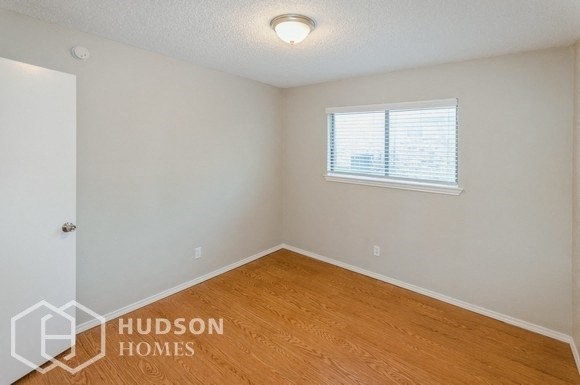 a room with a wooden floor and a window