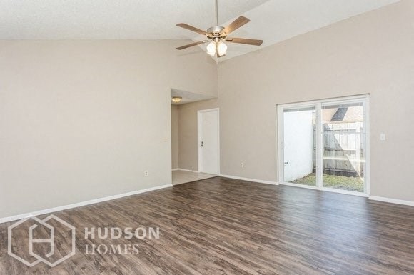 an empty living room with a ceiling fan and a window