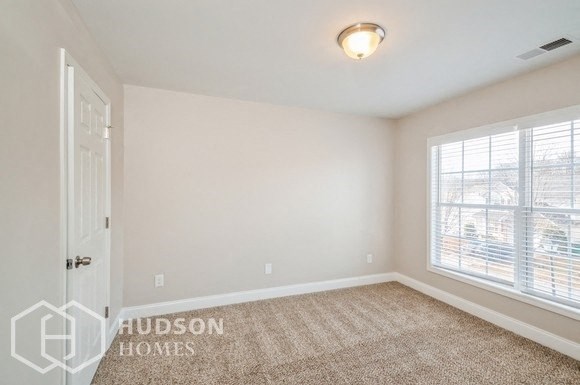 a white room with a window and a door and a carpet