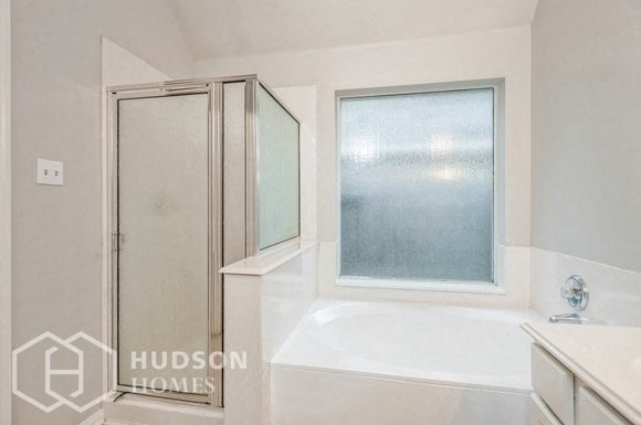 a white bathroom with a shower and a bath tub