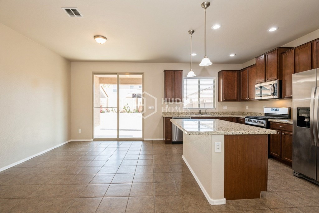 a large kitchen with an island and stainless steel appliances