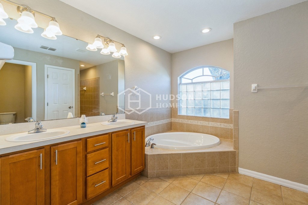 a bathroom with a tub and a sink and a mirror