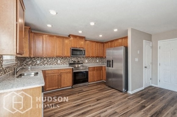 a kitchen with wooden cabinets and a stainless steel refrigerator