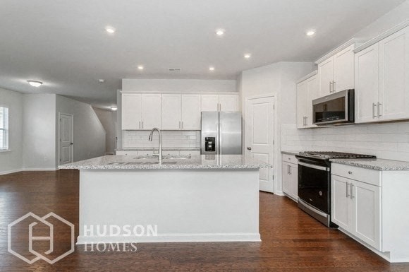 a large kitchen with white cabinets and a counter top