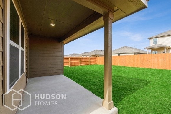 a covered walkway leading to a backyard with a fence and grass