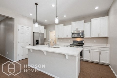 a large kitchen with white cabinets and a white counter top