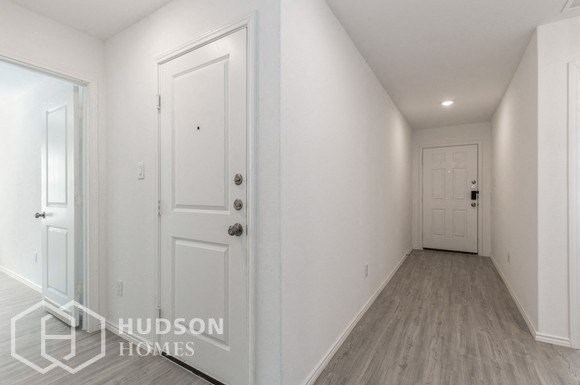 a white hallway with a white door and a white closet