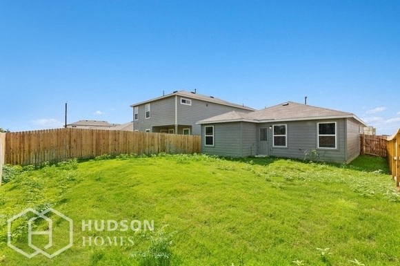 a backyard with a house and a grassy yard