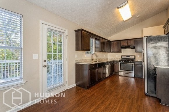 a kitchen with wooden floors and a door to a balcony