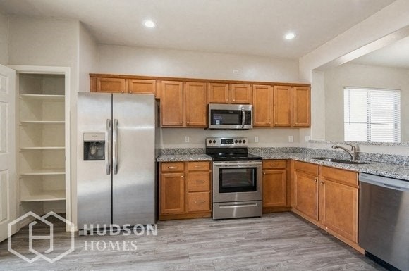 a kitchen with wooden cabinets and stainless steel appliances