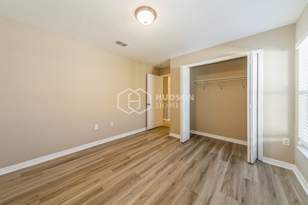 a bedroom with a closet and a mirrored closet door