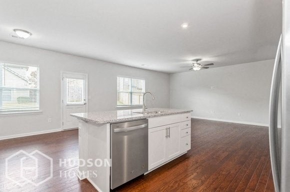 an empty kitchen with a counter top and a stainless steel sink