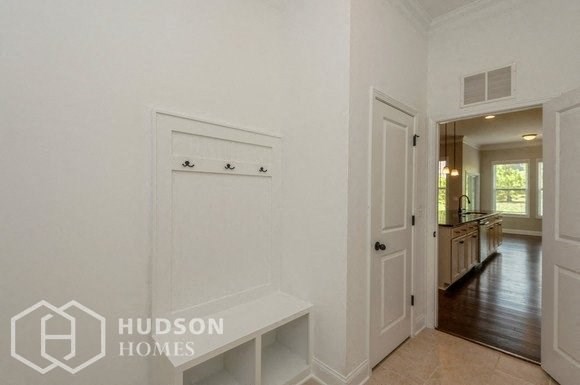 a white hallway with a white door and a white bench