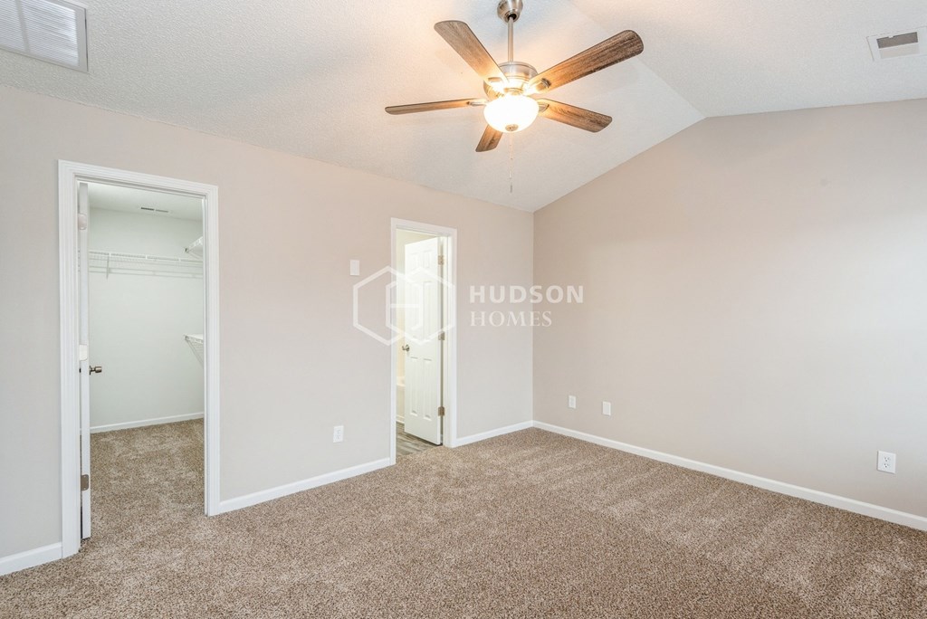 a bedroom with a ceiling fan and a door to a closet