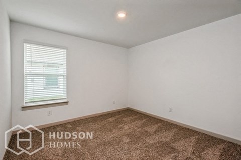 the living room of a home with a carpet and a window