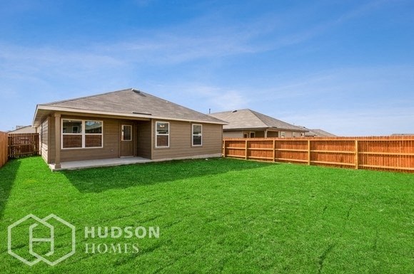 a backyard with a yard and a house and a fence