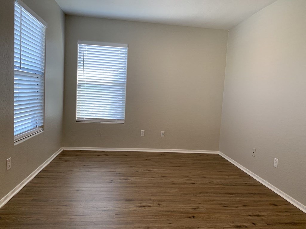 an empty room with wood floors and a window