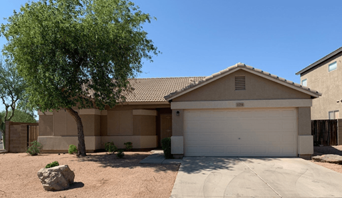 a house with a garage door and a tree