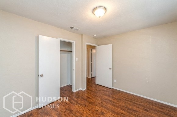 a living room with a hard wood floor and white walls