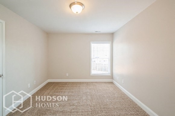 a empty room with a window and a carpeted floor