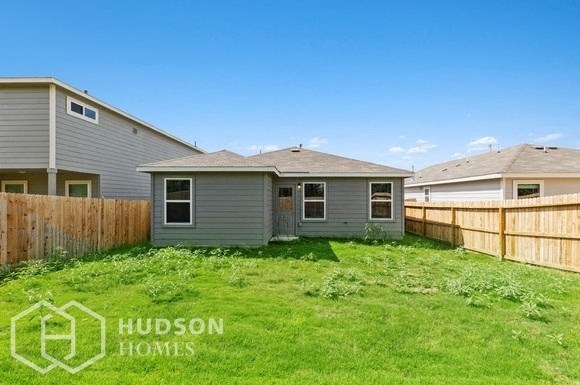 a backyard with a house and a fence