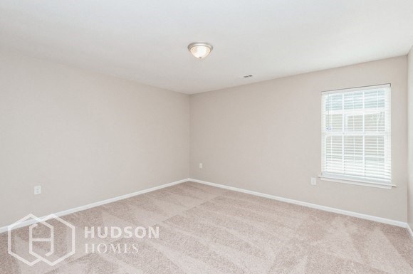 a bedroom with a carpeted floor and a window