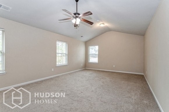 an empty living room with a ceiling fan and a window