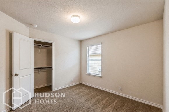 a bedroom with a closet and a white door and a window