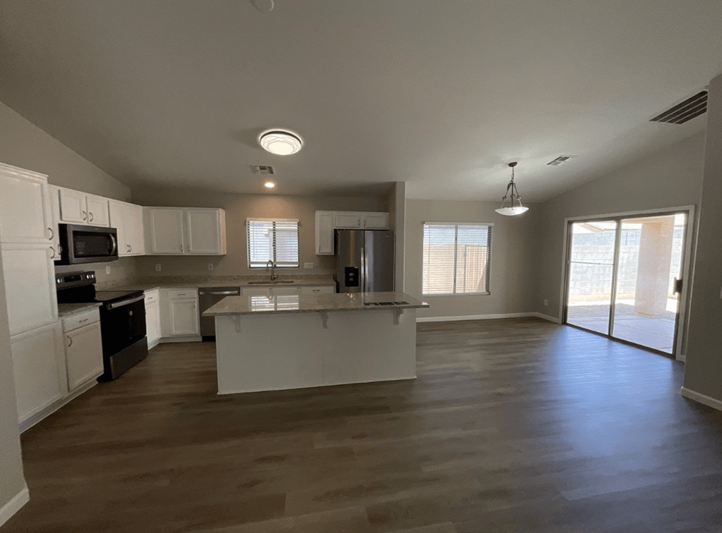 an empty kitchen with white cabinets and a counter top