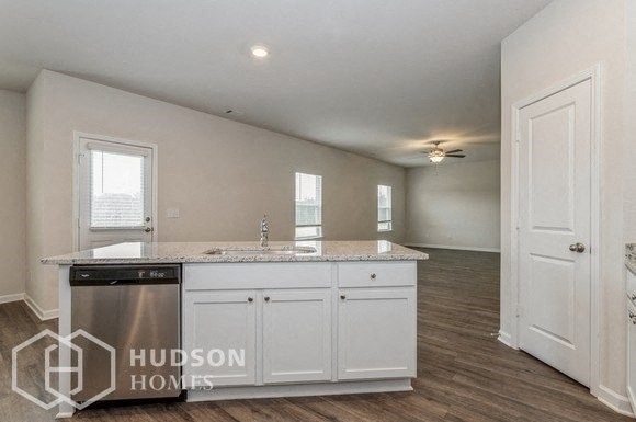 a kitchen with white cabinets and a sink and a dishwasher