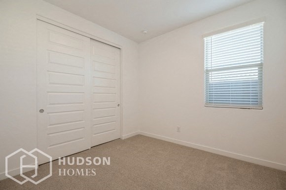 a bedroom with a closet and a door and a window
