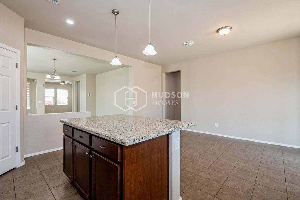 a kitchen with granite countertops and a island in the middle