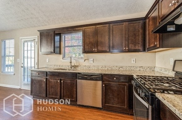 a kitchen with wooden cabinets and a stove and a sink