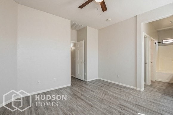 a living room with a ceiling fan and a door to a closet