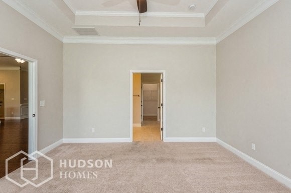 a living room with a carpeted floor and a door to a hallway