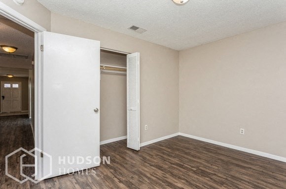 a bedroom with a closet and a door to a hallway