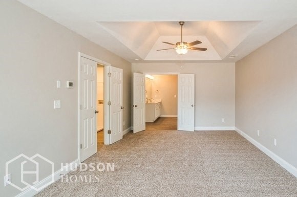 a living room with a ceiling fan and a carpeted floor